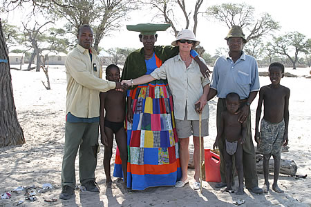Linette sharing a moment in time and giving the gift of clothes with a rural Botswana family enroute from Maun to Windhoek with vacationtechnician.com